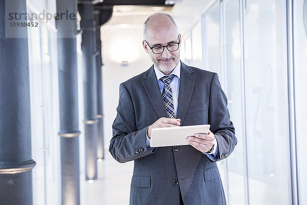 Reife Geschäftsleute mit digitalem Tablett