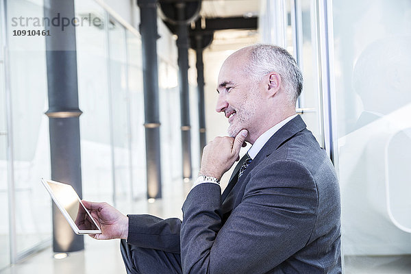 Reife Geschäftsleute mit digitalem Tablett