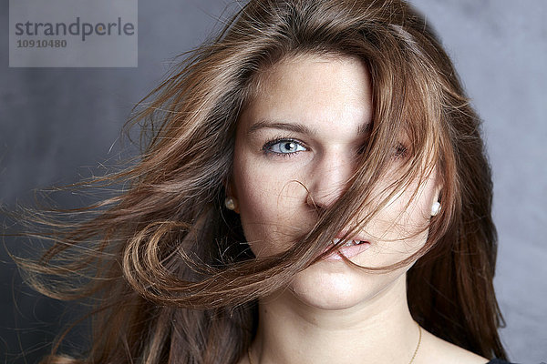 Porträt einer jungen Frau mit Haarsträhne im Gesicht