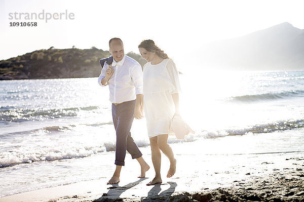 Spanien  Mallorca  schwangere Frau und Mann beim Spaziergang am Strand