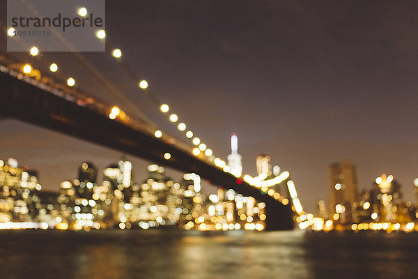 USA  New York City  verschwommene Skyline und Brooklyn Bridge bei Nacht