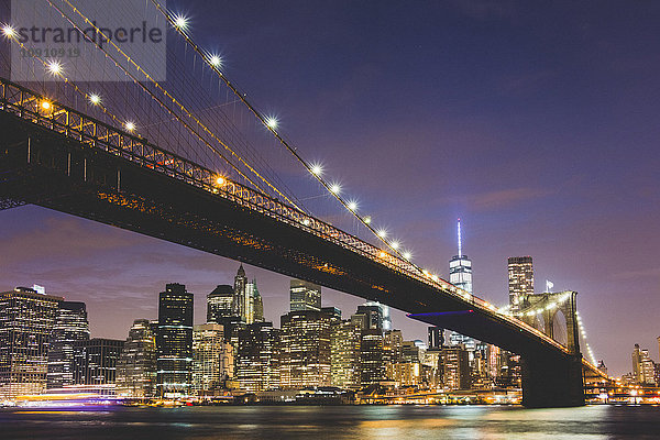 USA  New York City  beleuchtete Skyline und Brooklyn Bridge im Vordergrund bei Nacht