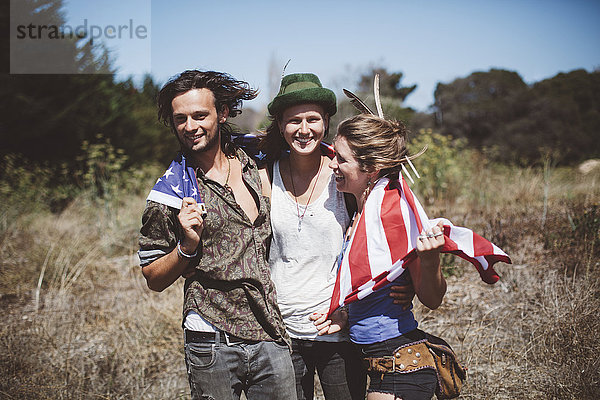 Drei Hippies mit US-Flagge in der Natur
