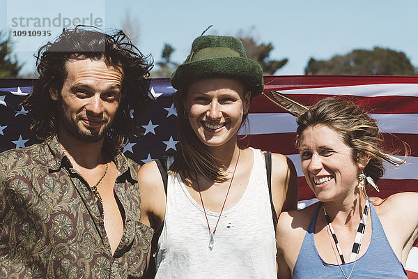 Porträt von drei lächelnden Hippies mit US-Flagge