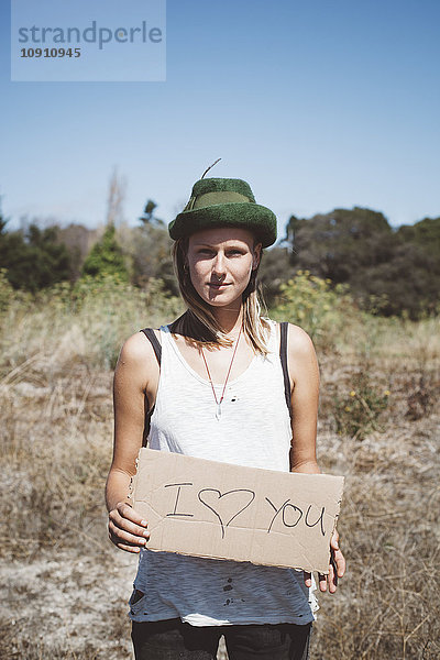 Hippie-Holding'Ich liebe dich' Schild in der Natur