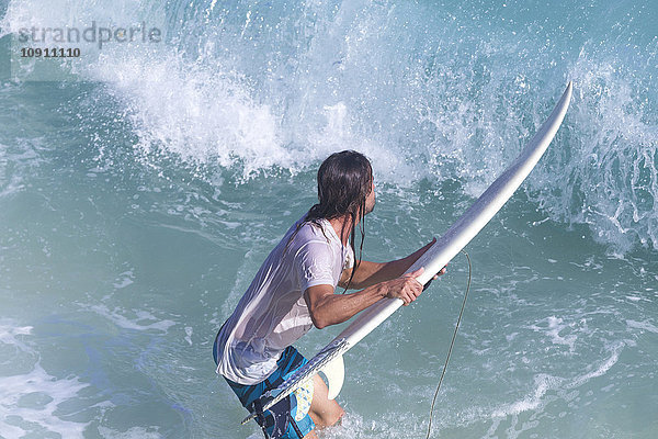 Indonesien  Bali  Surfer vor einer Welle