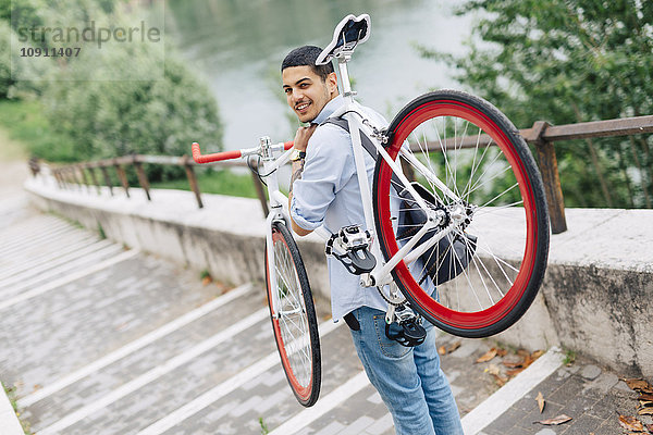 Junger Mann mit Fahrrad auf der Treppe