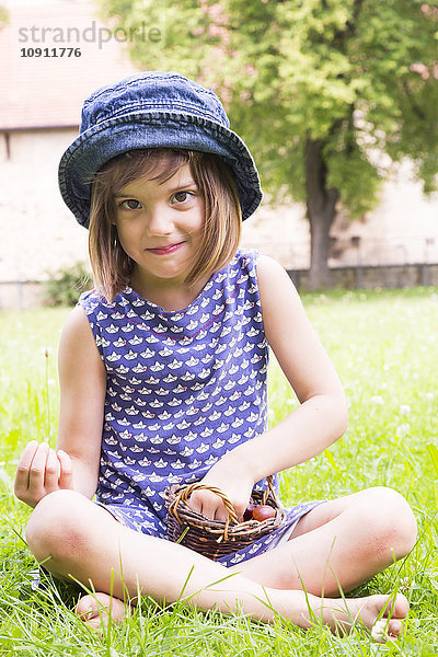 Bildnis eines kleinen Mädchens auf einer Wiese mit Stachelbeerkorb