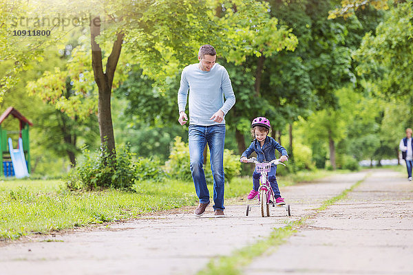 Vater begleitet Tochter auf dem Fahrrad
