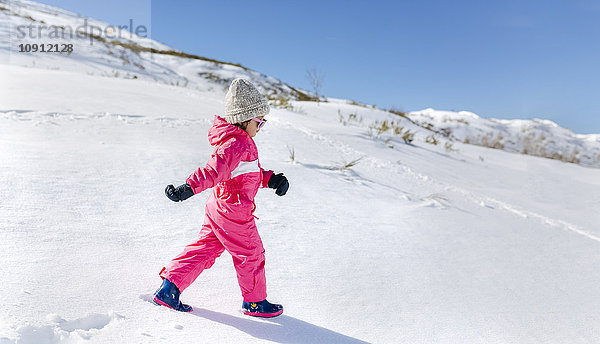 Kleines Mädchen  das im Schnee läuft