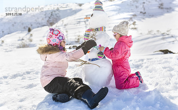 Spanien  Asturien  Kinder spielen mit Schneemännern in schneebedeckten Bergen