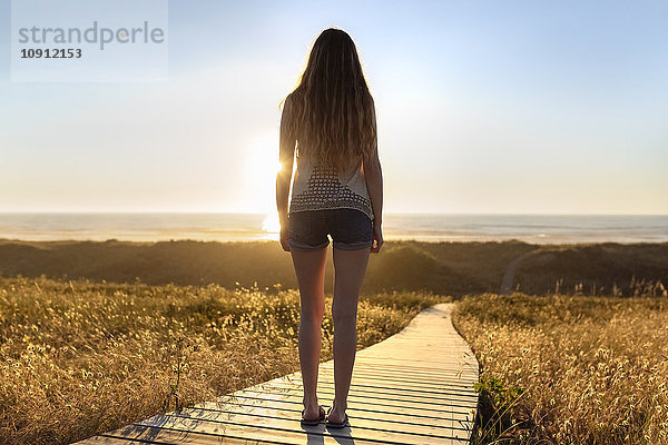 Junge Frau an der Strandpromenade stehend