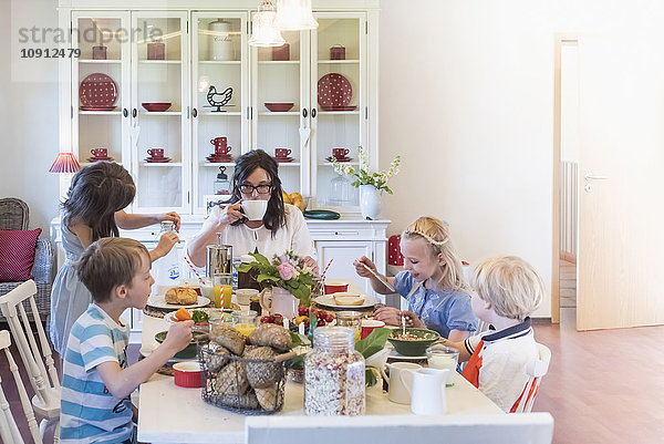 Mutter und vier Kinder beim Frühstück