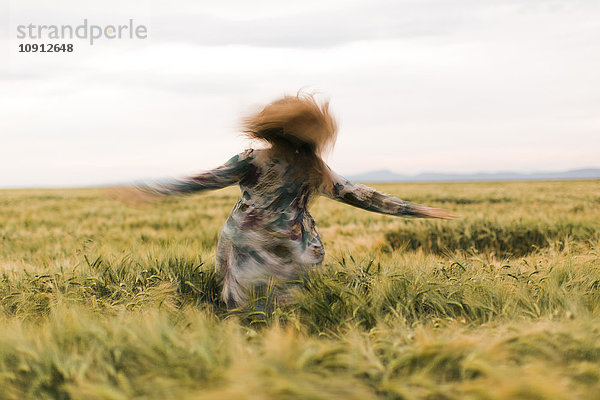Frau tanzt auf einem Feld