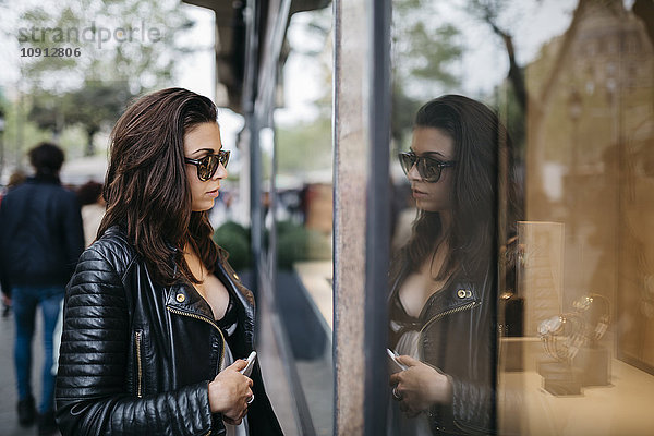 Junge Frau in der Stadt mit Blick auf das Schaufenster