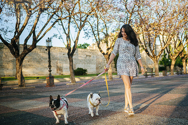 Frau geht mit ihren beiden Hunden spazieren