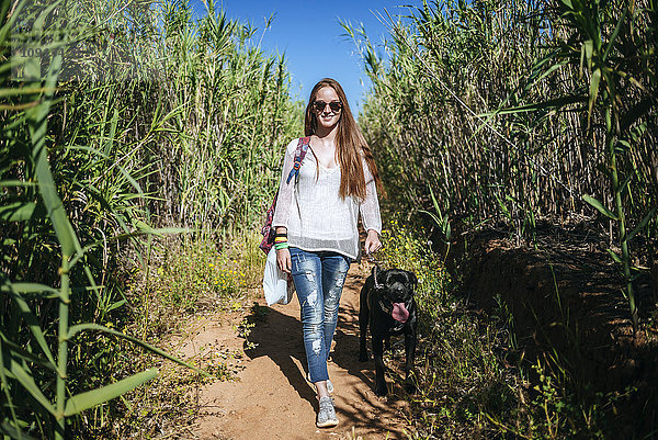Junge Frau mit ihrem Hund in ländlicher Landschaft