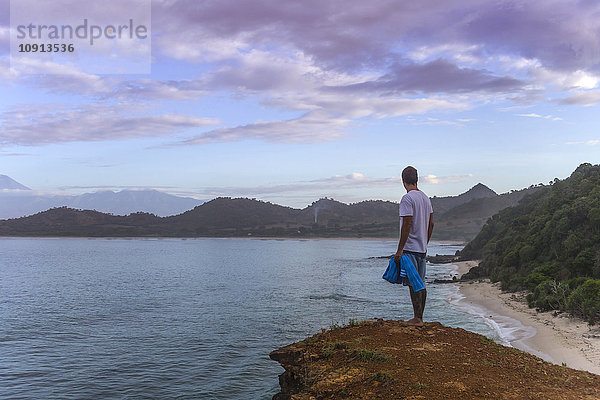 Indonesien  Insel Sumbawa  Junger Mann steht auf Aussichtspunkt