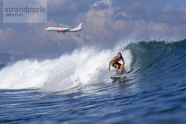 Indonesien  Bali  Surfer auf Welle  Flugzeug im Hintergrund