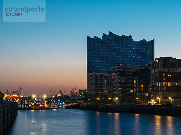 Deutschland  Hamburg  Elbphilharmonie mit Mehrfamilienhäusern im Vordergrund zur blauen Stunde