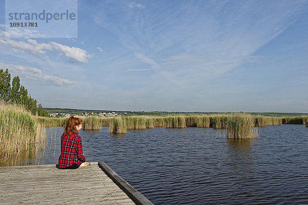 Österreich  Burgenland  Neusiedler See  Moerbisch  junges Mädchen am Steg sitzend
