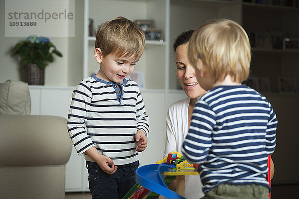 Zwei kleine Jungen  die zu Hause mit ihrer Mutter spielen.