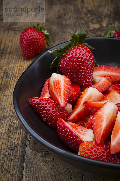 Schale mit geschnittenen und ganzen Erdbeeren