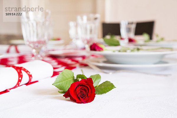 Rote Rose auf gedeckten Tisch am Valentinstag