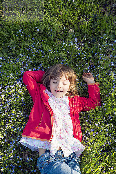 Porträt eines kleinen Mädchens mit geschlossenen Augen auf einer Wiese