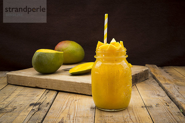Glas Mango-Smoothie garniert mit gewürfelter Mango