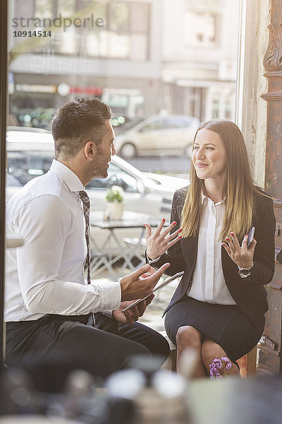 Geschäftsmann und Geschäftsfrau diskutieren in einem Cafe