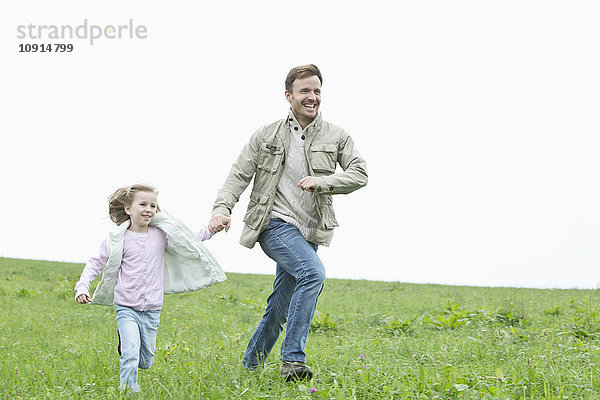 Glücklicher Vater und Tochter auf der Wiese unterwegs