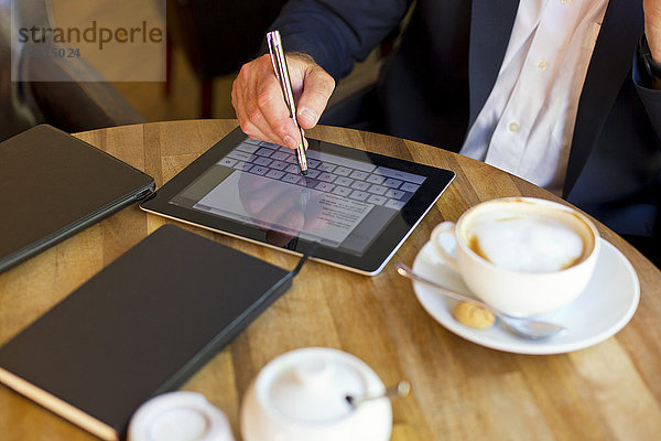 Geschäftsmann im Coffee-Shop mit digitalem Tablett  Teilansicht