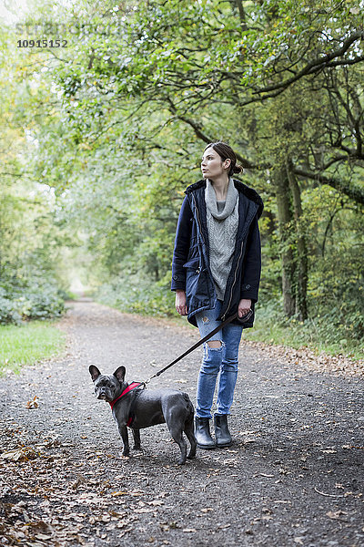 Frau  die mit dem Hund spazieren geht