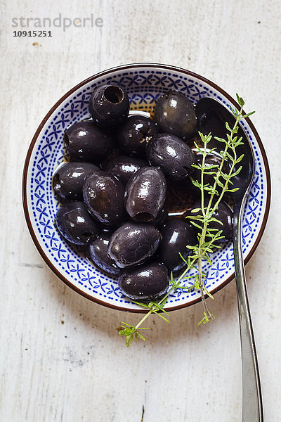 Schwarze Oliven in Schale mit Thymian