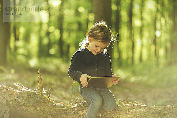 Mädchen im Wald mit digitalem Tablett