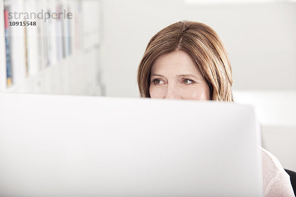 Porträt einer Frau hinter ihrem Computer