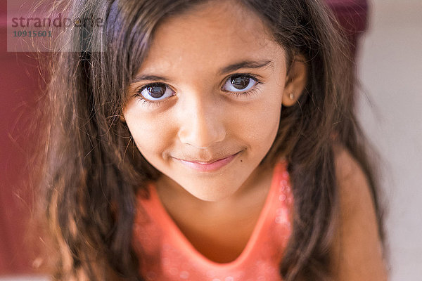Porträt eines lächelnden kleinen Mädchens mit langen braunen Haaren