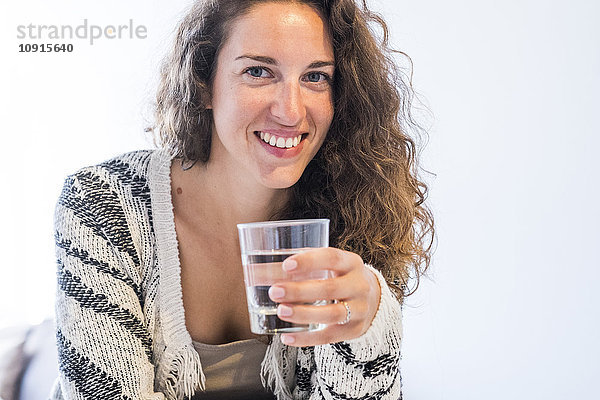 Porträt einer lächelnden Frau mit Wasserglas