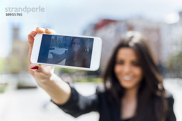 Junge Frau macht einen Selfie  Display von Smartphone