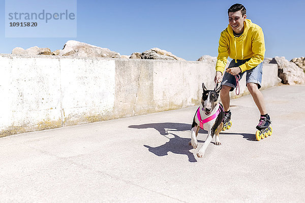 Inline-Skater mit seinem Bullterrier