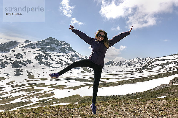 Spanien  Asturien  Somiedo  verspielte Frau beim Springen in den Bergen