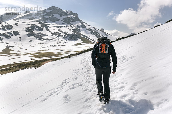 Spanien  Asturien  Somiedo  Mann beim Wandern in verschneiten Bergen