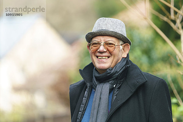 Porträt eines glücklichen Senioren mit Hut und Brille