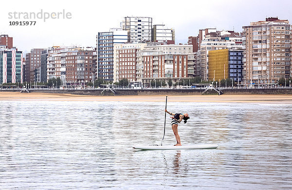 Spanien  Gijon  Frau beim Paddelboard-Yoga
