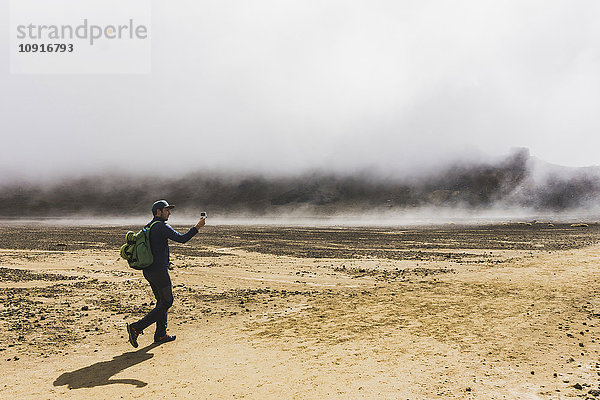 Neuseeland  Tongariro Nationalpark  Wanderer beim Fotografieren mit Smartphone