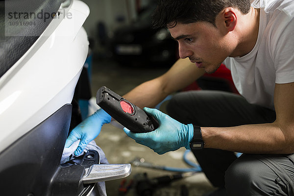Junge Mechaniker reparieren Motorroller in der Garage