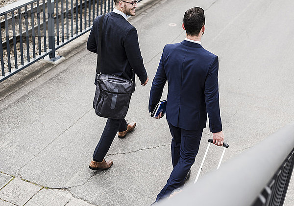 Geschäftsleute auf Geschäftsreise zu Fuß mit Rollgepäck