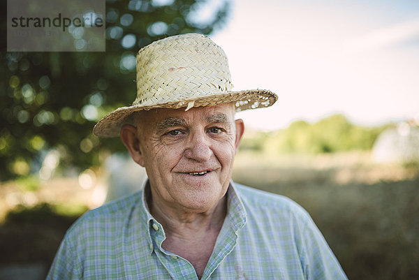 Porträt eines lächelnden Bauern mit Strohhut