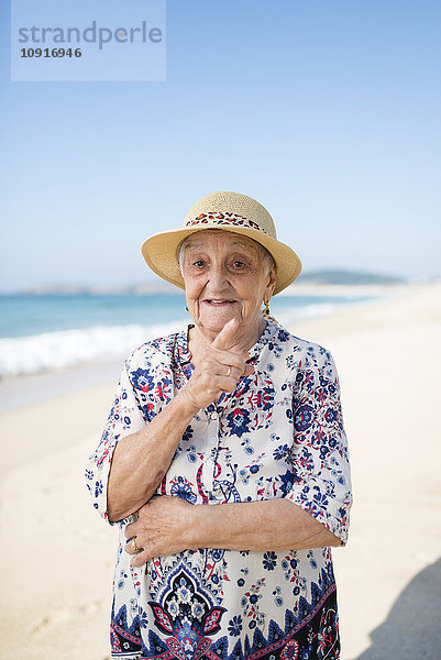 Porträt einer älteren Frau am Strand stehend